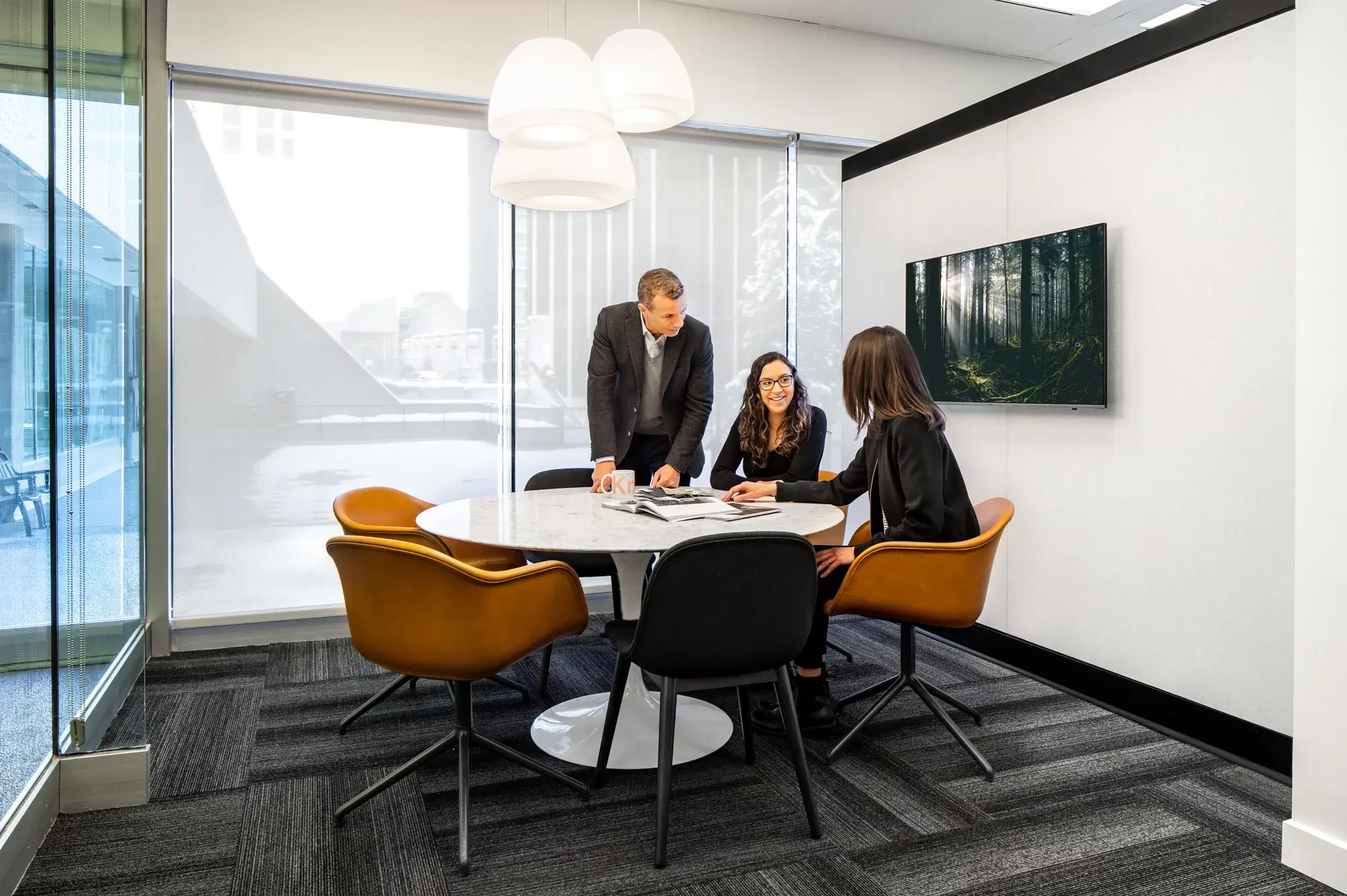 Three people meeting around a table in a workplace